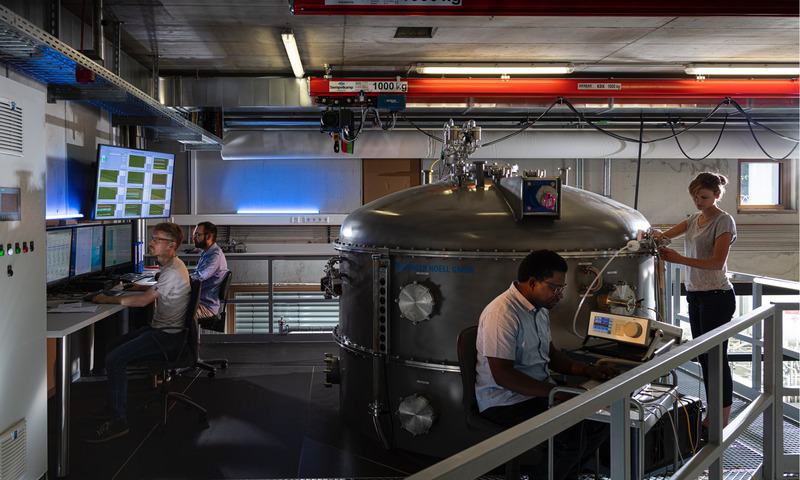 Wissenschaftler bedienen und überwachen ein großes Laborgerät in der Forschungsinfrastruktur AIDA